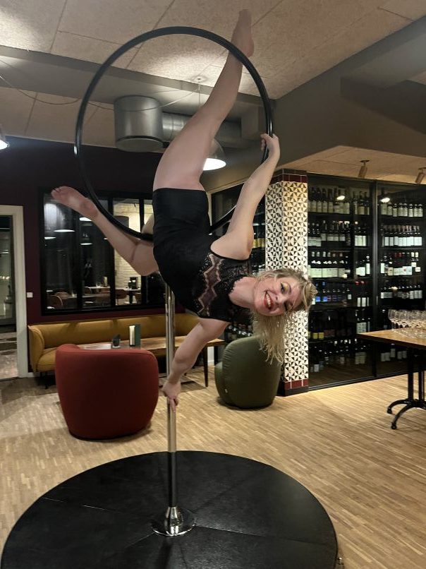 An aerialist performing at a corporate event. You can book a performer from Pole Republic. En aerialist der optræder til et firmaevent. Book en performer gennem Pole Republic.